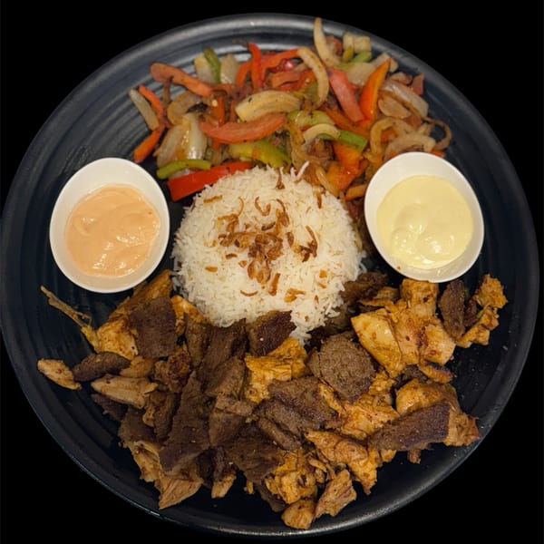Sharjah Mediterranean Grill's shawarma plate with chicken, beef, rice, sautéed vegetables, and two sauces.