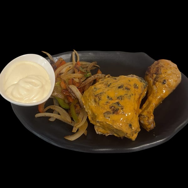 Sharjah Mediterranean Grill's chicken with creamy sauce, sautéed onions, peppers, and a side of white sauce.